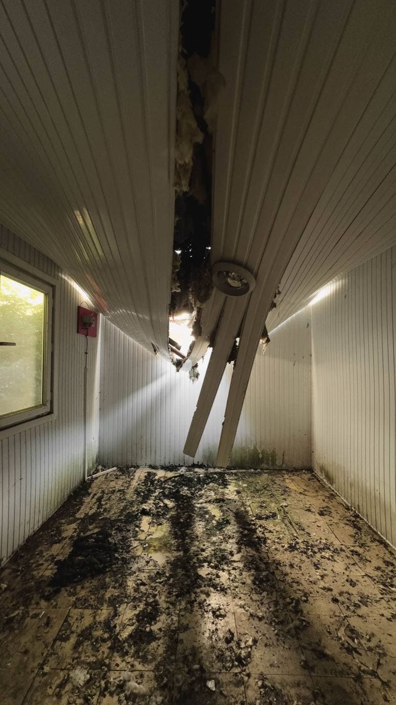 Room with a collapsed ceiling and debris across the floor