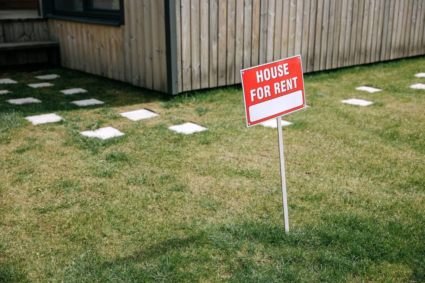 House for rent sign on a front lawn