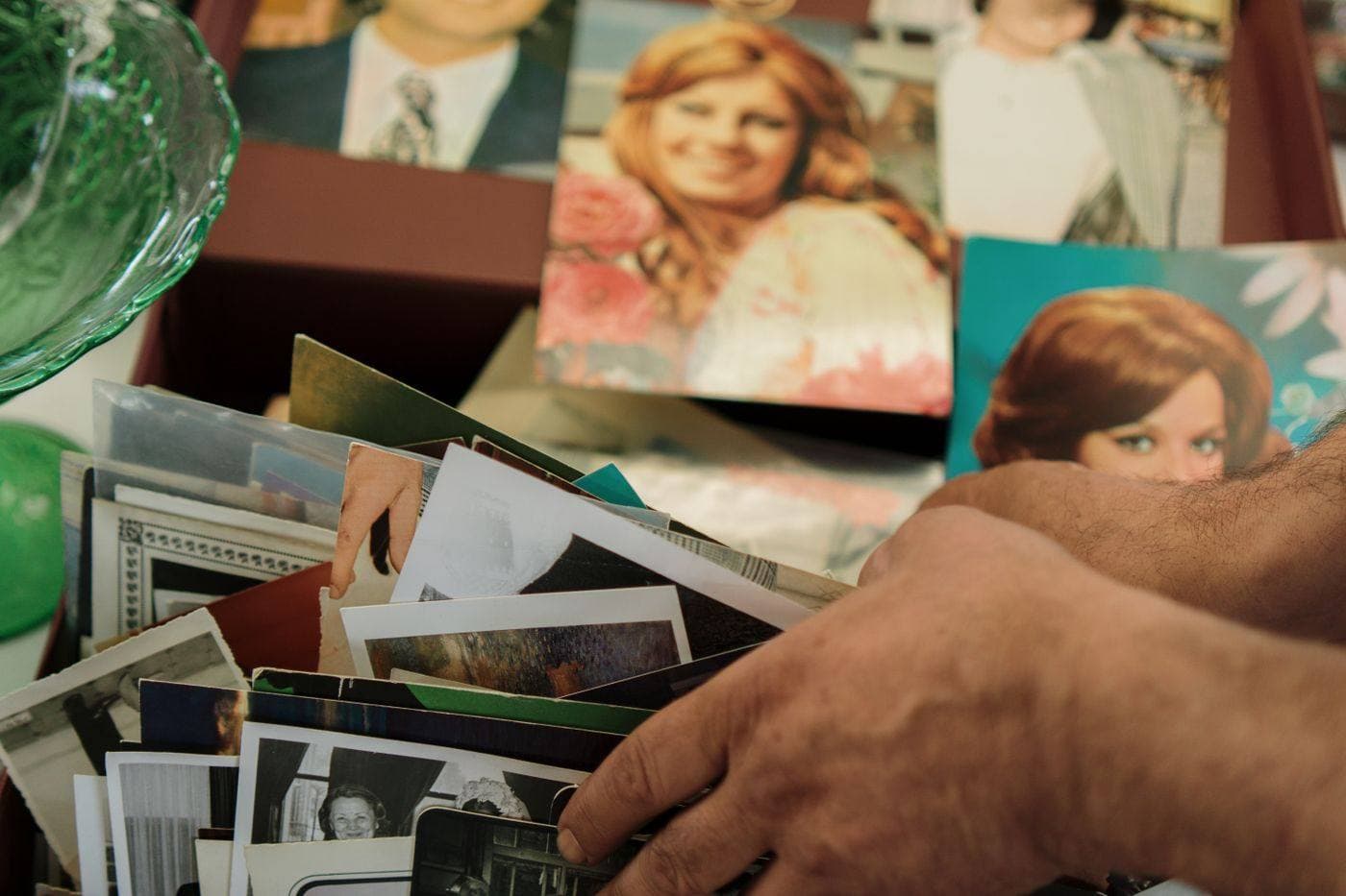 Hands sorting family photographs on a table