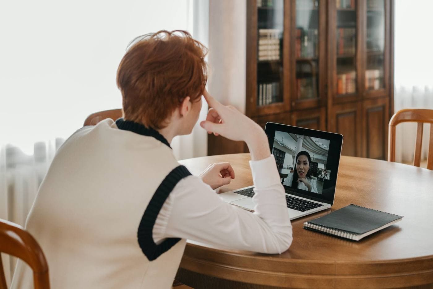 Person on a video call at a laptop on a dining table