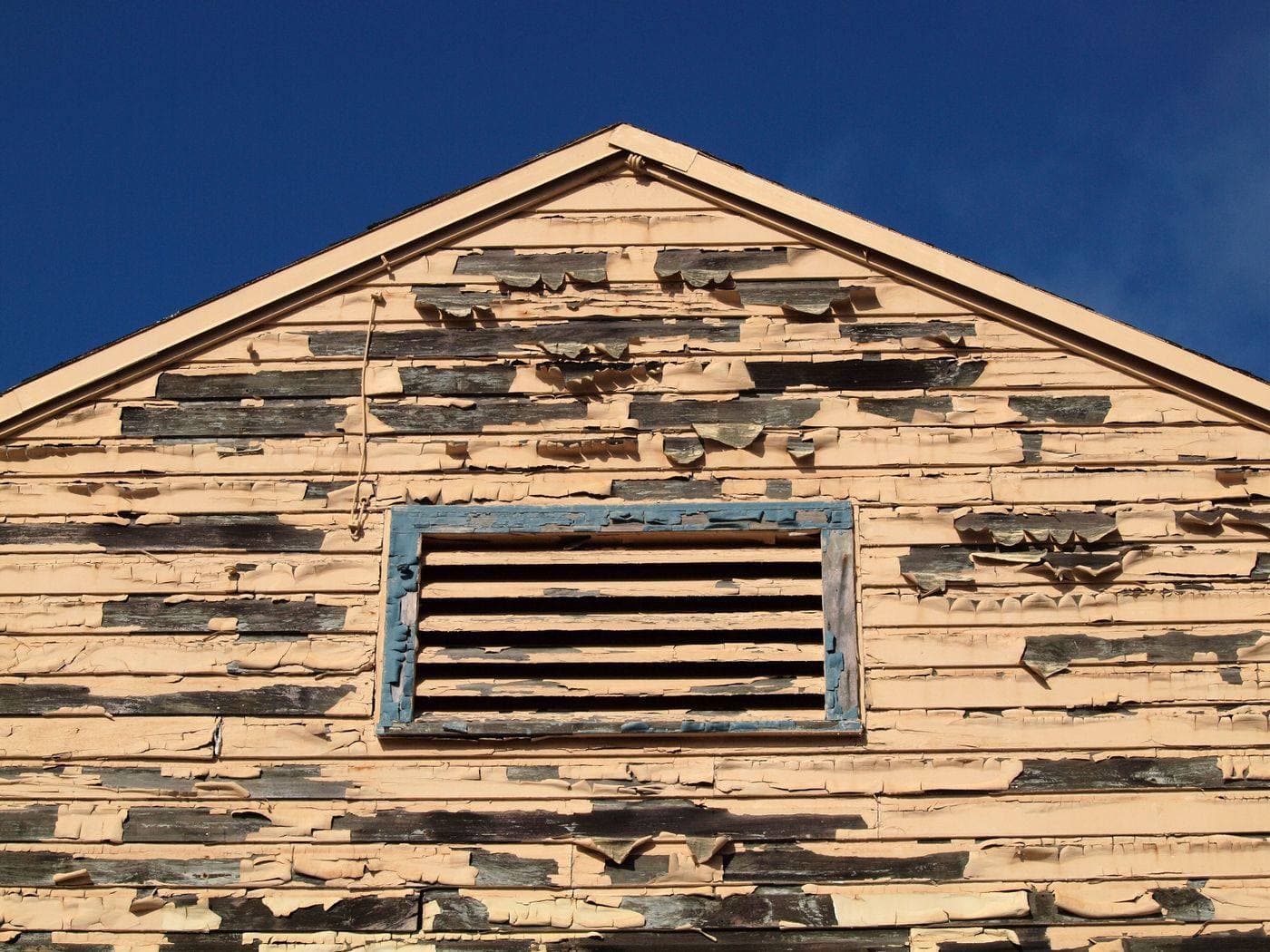 An older wooden house with peeling exterior paint